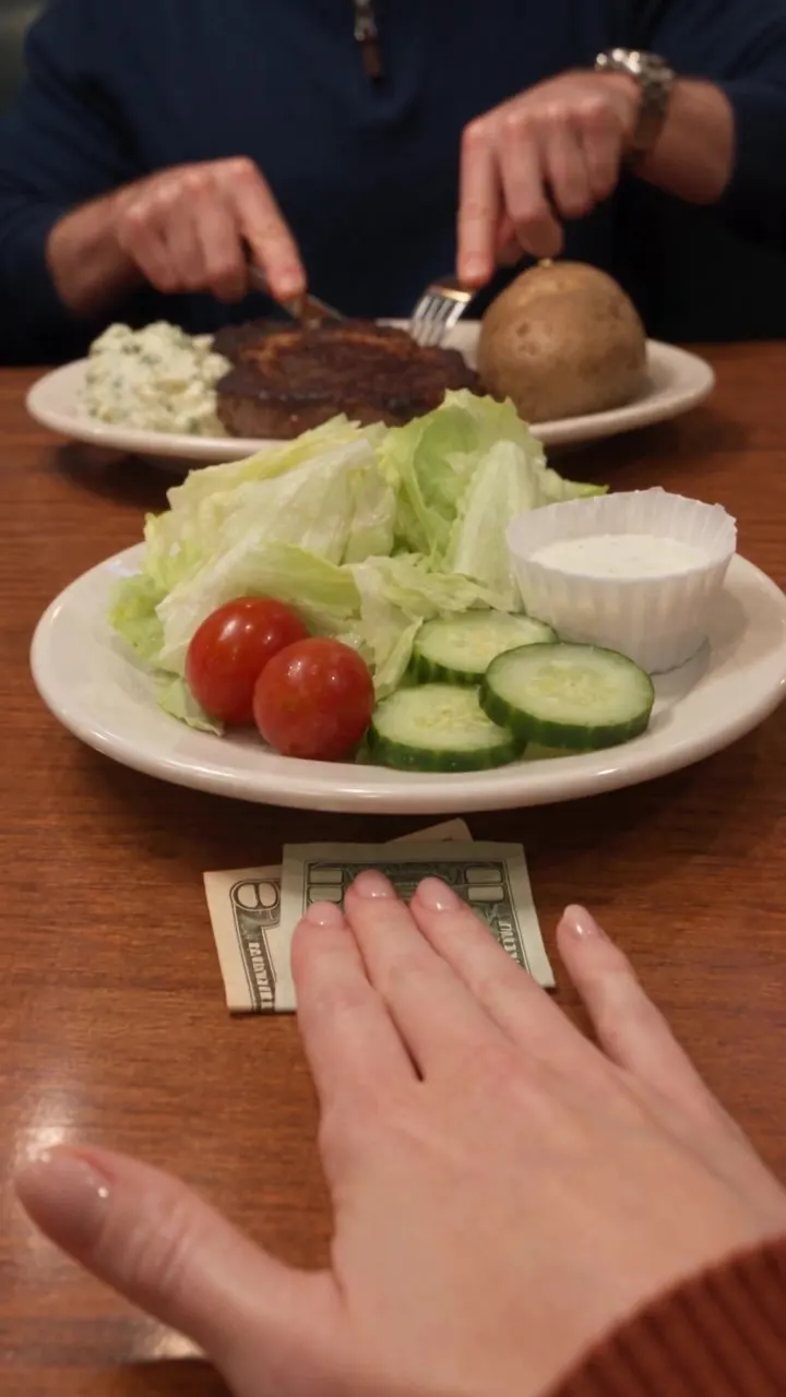 The side salad: iceberg, two tomatoes, cucumber coins, and your eleven dollars beside it.